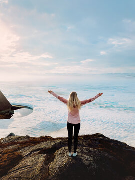 Tourist woman explore Norway enjoying snowy frozen lake in mountains travel healthy lifestyle freedom female tourist raised hands on active adventure winter vacations trip outdoor harmony with nature