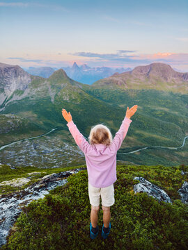 Child travel in Norway on hiking family vacations outdoor in Norway - kid girl enjoying Stetind mountain view happy raised hands healthy lifestyle fun happy emotions on summer holidays adventure trip