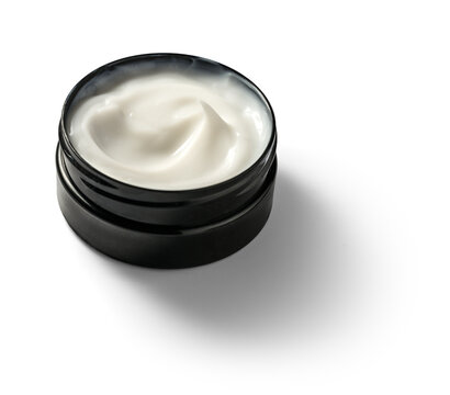 White cream swirls in sleek black jar isolated on transparent