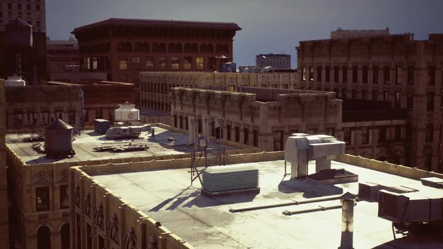 Historic water tower against skyline with wooden tank and metal supports, layered city blocks and varied rooflines create vintage urban character