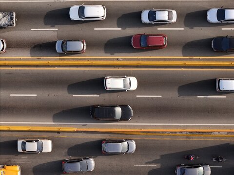 Aerial view of traffic on Avenida John F. Kennedy with various cars and motorcycles moving along the highway in Santo Domingo, Distrito Nacional, Dominican Republic.