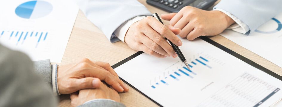 Business meeting, asian group brainstorm analysis on graph data of cost plan. financial consult planning investor asses and present to client, client and advisor review investment strategy in office.