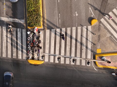 Aerial view of pedestrians crossing the street at a crosswalk on Avenida John F. Kennedy in Santo Domingo, Distrito Nacional, Dominican Republic.