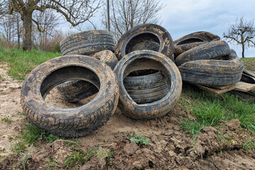 Pile of old tires dumped in nature. Illegal waste disposal and environmental pollution © Firn