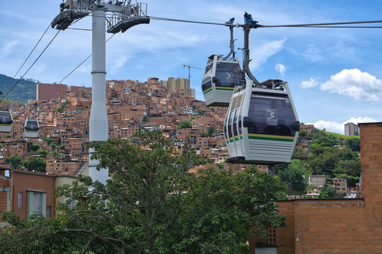 Metrocable gondola passes close to rooftops in a hillside neighborhood of Medell&iacute;n, Colombia, on July 31, 2026