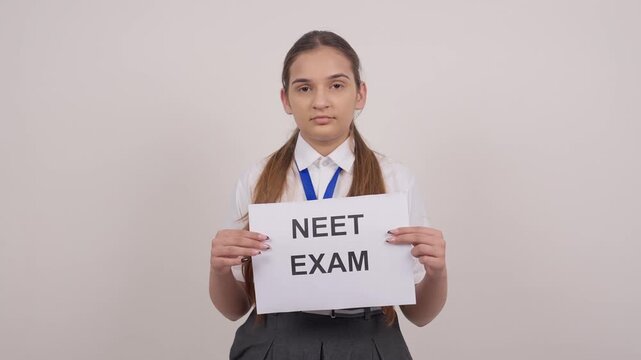 Indian Schoolgirl Standing with NEET EXAM Poster