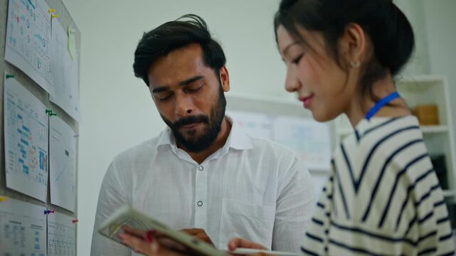 Coworkers discussing business in modern office.Tablet,meeting and business people in office at for research project, website review and internet.Working together on project.Two business colleagues