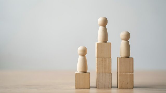 Wooden figures standing on blocks of different heights representing hierarchy and success in business