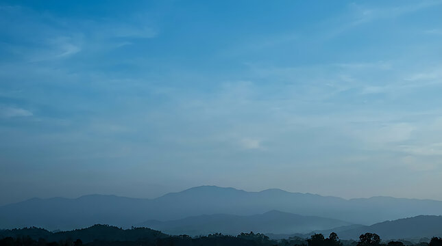 Distant mountain range silhouetted against a gradient blue sky showcasing atmospheric perspective mountains silhouettes horizon landscape
