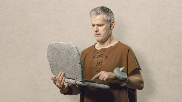 Funny Caveman Working on a Primitive Stone Laptop - Prehistoric