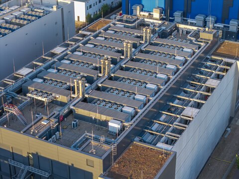 Aerial view of a modern data center rooftop featuring rows of industrial cooling units and ventilation systems in Frankfurt am Main, Hessen, Germany.