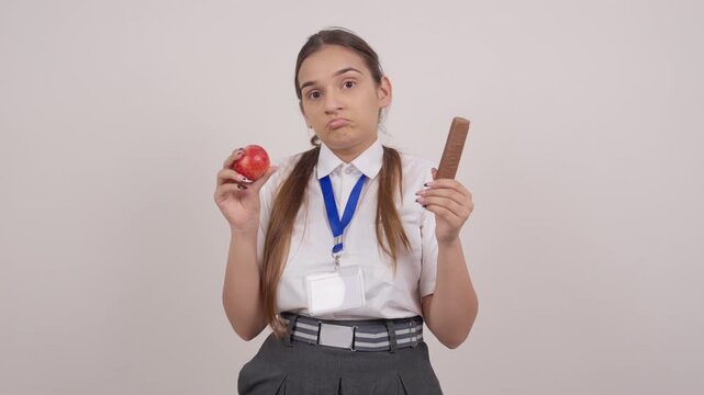 Indian Schoolgirl Confused Between a Fresh Apple and a Chocolate Bar