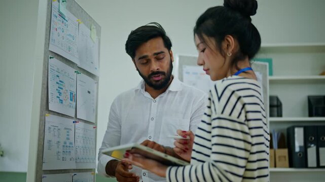 Coworkers discussing business in modern office.Tablet,meeting and business people in office at for research project, website review and internet.Working together on project.Two business colleagues