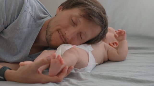 Father listening to his three month old baby son's belly. Slow motion.