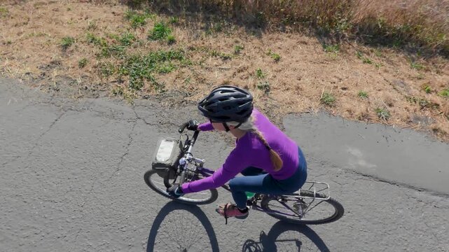 Overhead view of woman riding her bike on a trail in Fort Bragg near the ocean enjoying the sunny weather and exploring the area