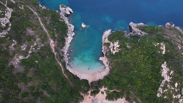 Top down aerial view over famous Porto Timoni double beach and crystal clear turquoise water. Rugged coastline of Ionian sea, amazing green cliffs Corfu Greece