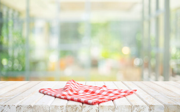 Selective focus.Fabric cloth or placemat on wood table top on flower garden background.For montage product display