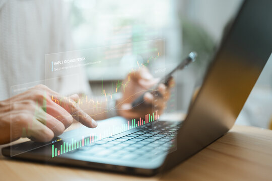 Hands work at a laptop beneath a candlestick chart as stock market trends guide investment choices and detailed analysis compares price movement before a portfolio adjustment as conditions change.