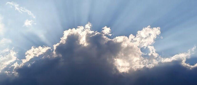 View of a partly cloudy sky with shafts of sunlight