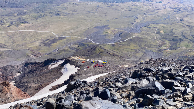 Tents marking high camp in elevated view on Mount Ararat, Turkey, with snow patches, volcanic rocks