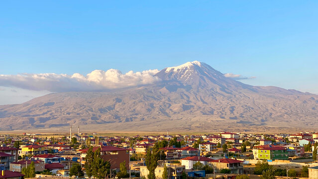 Dawn illuminating Mount Ararat in wide city view from Dogubayazit, Turkey, with urban rooftops