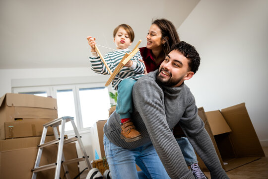 Father carrying his young son on his back while moving home