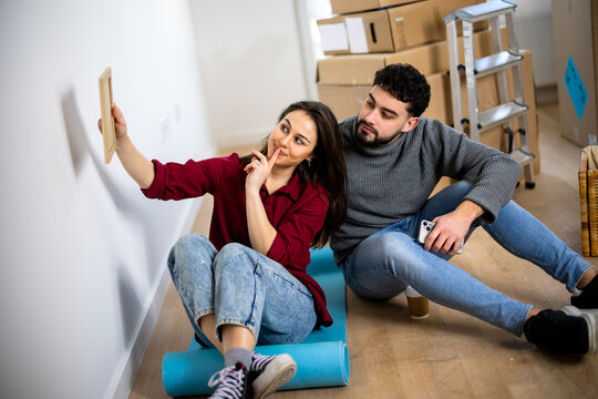 Couple relaxing on the floor with rolled yoga mats during a home move