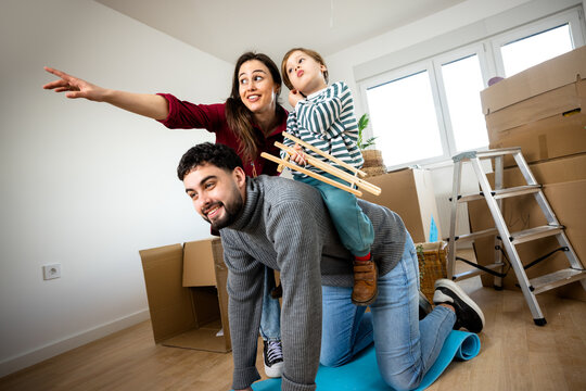 Mother pointing while father carries their son during a home move