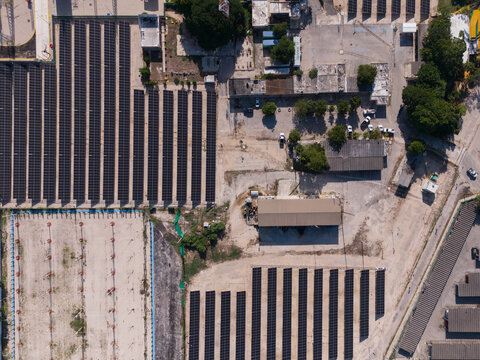 Aerial view of solar panel arrays at the CFE facility with industrial buildings and surrounding grounds in Merida, Yucatan, Mexico.