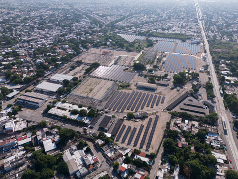 Aerial view of the CFE Merida Area electrical substation featuring rows of solar panels and industrial infrastructure surrounded by the urban landscape of Merida, Yucatan, Mexico.