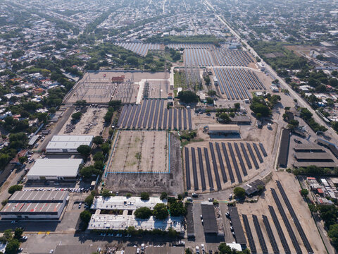 Aerial view of the CFE Merida Area solar power facility and electrical substation, featuring rows of solar panels and industrial buildings in Merida, Yucatan, Mexico.