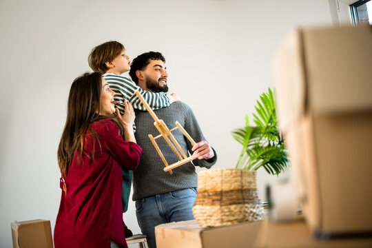 Parents holding their young son while moving home