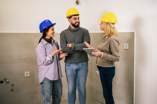 Construction team reviewing plans together during an indoor renovation project