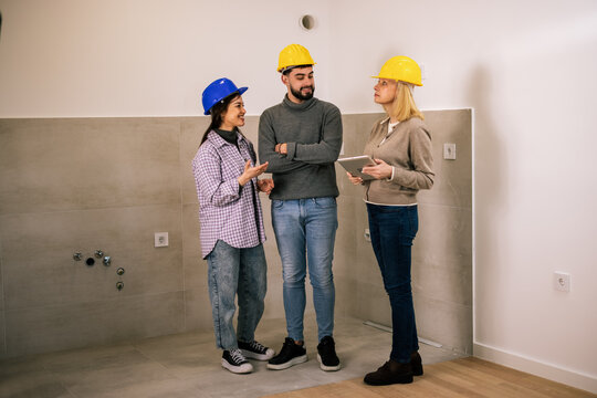 Three construction professionals discussing a building project indoors