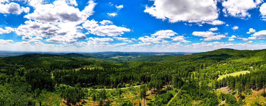 Aerial view of the lush green forests and rolling hills surrounding the Grosser Feldberg in the Taunus mountain range in Schmitten im Taunus, Hessen, Germany.