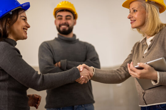 Construction professionals shaking hands during a renovation project