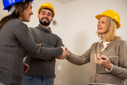 Construction workers shaking hands during an indoor renovation project