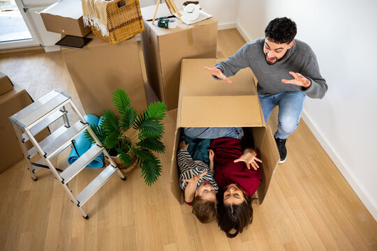 A man and woman play with a large cardboard box during a home move