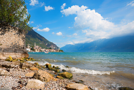 Small swimming beach Gargnano, with views of the village and mountains. Lake Garda landscape.