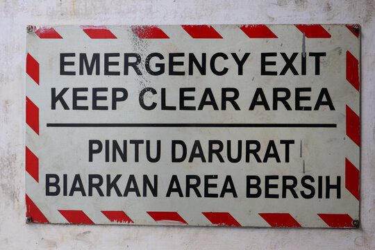 Bilingual Emergency Exit Keep Clear Warning Sign on Wall.