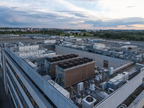 Aerial view of an AI data center cooling system with industrial HVAC units and fans on a rooftop at sunset in Krakow, Lesser Poland Voivode, Poland.