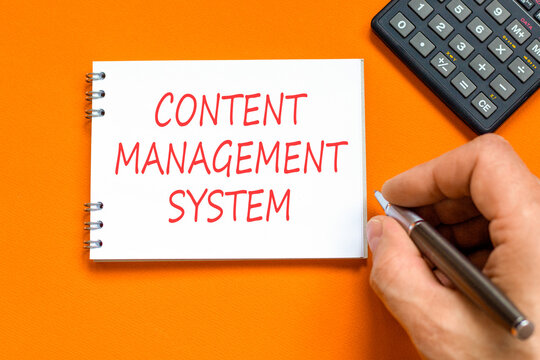 Content management system symbol. Concept words Content management system on beautiful white note. Beautiful orange background. Businessman hand. Business content management system concept. Copy space