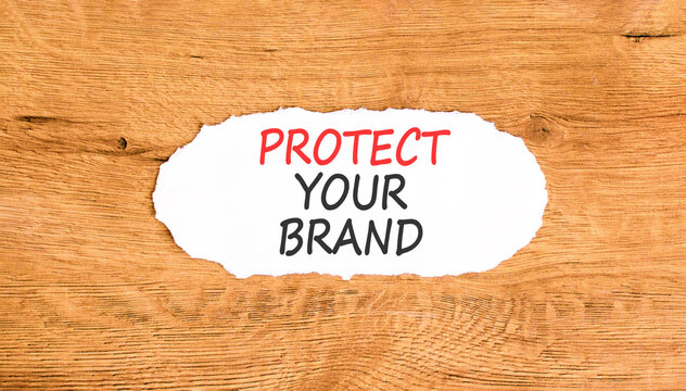Protect your brand words symbol. Concept words Protect your brand on beautiful white paper. Beautiful wooden background. Business and protect your brand concept. Copy space.