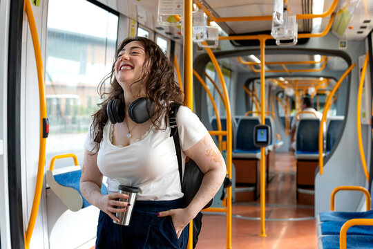 Happy woman with vitiligo commuting on murcia tram, enjoying urban public transport