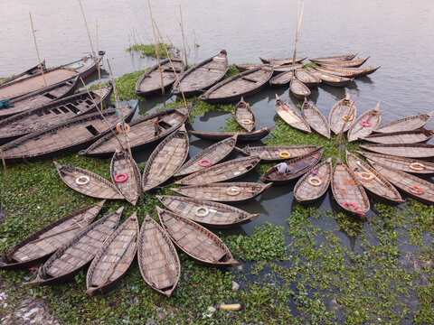 Aerial view of wooden boats arranged in a flower-like pattern on the Buriganga River in Dhaka, Bangladesh.