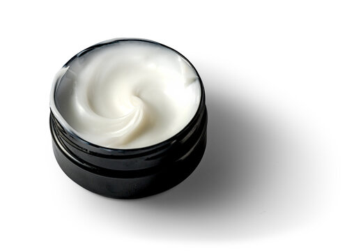 White cream swirls in sleek black jar isolated on transparent