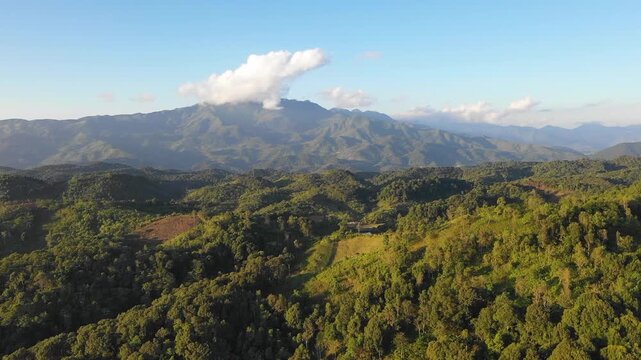 Drone footage capturing a panoramic view of the green mountains and dense forests surrounding the summit of Dinh Mang But Pu Cha, near Dien Bien Phu in northwest Vietnam.