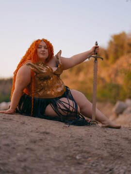 Plus Size Redhead Warrior Woman Resting Cliff Holding Sword