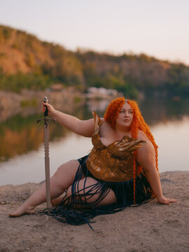 Plus Size Redhead Warrior Woman Resting by Lake Holding Sword