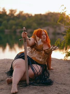 Plus Size Redhead Warrior Woman Resting by Lake Holding Sword